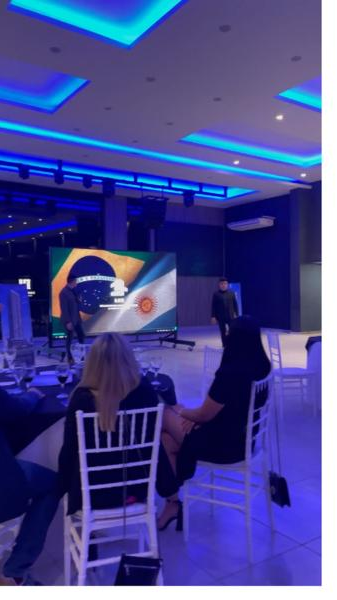 Plateia diante de telão com bandeiras do Brasil e da Argentina