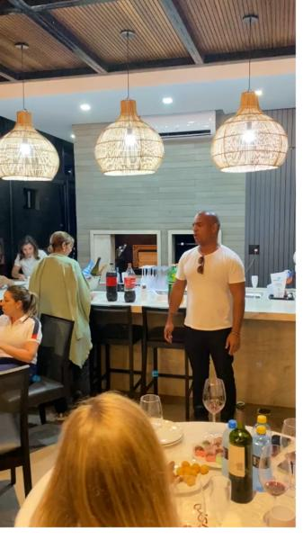 Roberto falando para um grupo em um restaurante